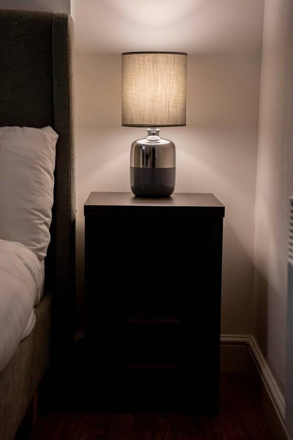 A small bedside table with a lamp and a bedside table lamp.