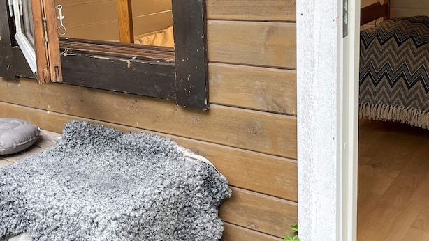 A wooden exterior wall with a gray textured rug on the ground. - 4 Person Holiday Park Home in Vaxholm (Vaxholm)