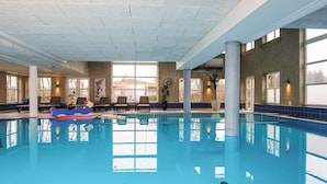 An indoor swimming pool with clear blue water, sunlit windows, and lounge chairs along the poolside. - 6 Person Holiday Park Home in Romo (Rømø)