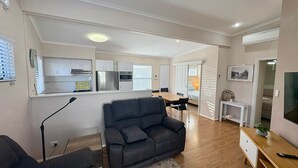 Un appartement moderne comprenant un salon, une cuisine, un coin repas et une chambre.