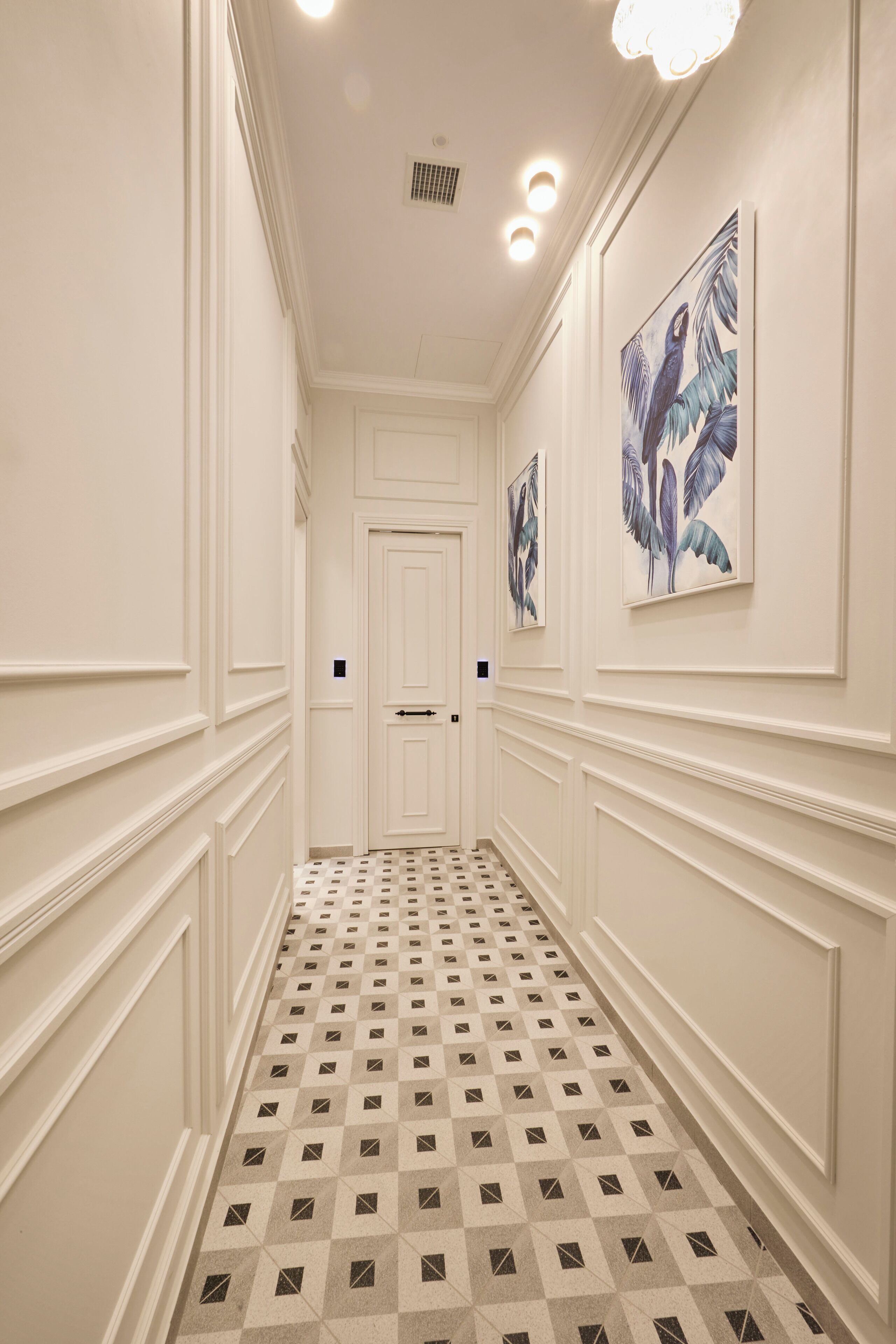 A hallway with a checkered floor, white walls, and two doors.