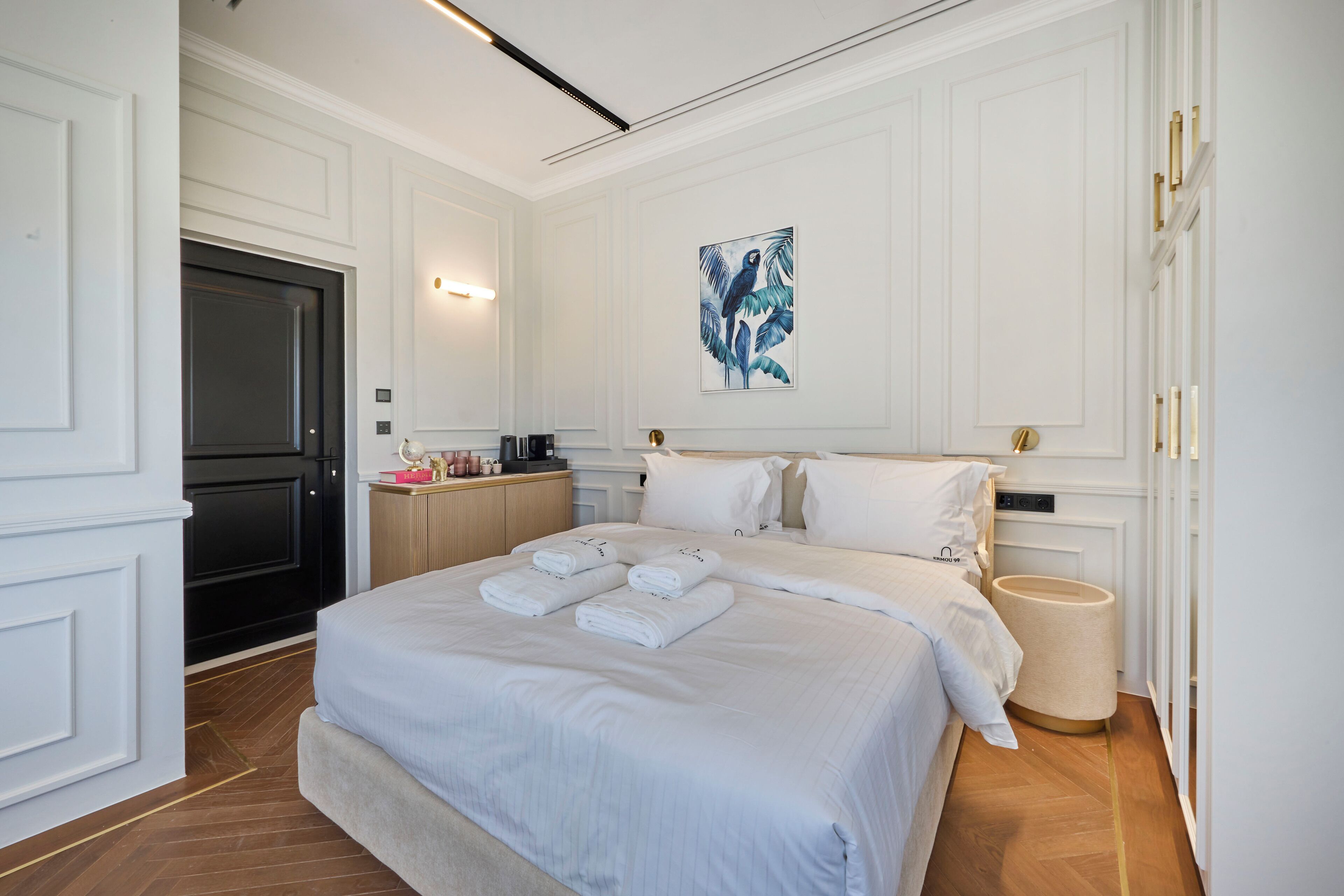 Ein Hotelzimmer mit einem großen Bett, einem Nachttisch, einer Wanddekoration und einer Tür.