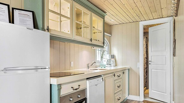 A kitchen with wooden cabinets, a dishwasher, and a refrigerator.