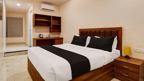 Ein ordentlich eingerichtetes Schlafzimmer mit Bett, Nachttisch und einer integrierten Regaleinheit.