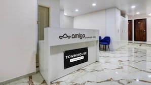 Ein Empfangstresen mit einem Schild, auf dem 'amigo premium stay' und 'TOWNHOUSE Company-Serviced' steht.