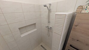 Regadera, secadora de cabello, toallas, papel de baño 
