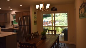 A kitchen with a dining area, a chandelier, and a view of the outdoors.
