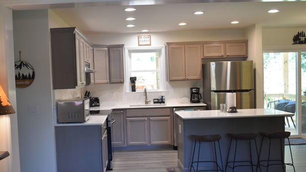 A modern kitchen with a central island, stainless steel appliances, and a view to the outdoors.