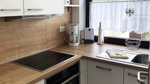 A modern kitchen with a built-in oven, a coffee maker, and a kettle on the countertop. - Winterberg Apartment 21041 (Winterberg)