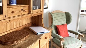 A wooden dresser with drawers, a laptop, and a woven mat on top. - Winterberg Apartment 21041 (Winterberg)