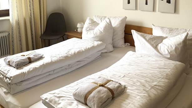 A hotel room with two beds, each with neatly folded white towels and pillows. - Winterberg Apartment 21041 (Winterberg)