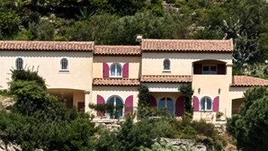 A multi-story building with a tiled roof, arched windows, and a stone base. - MAGNIFICENT VILLA SEA VIEW 4 BEDROOMS SWIMMING POOL QUIET ON THE HEIGHTS OF BORMES (Bormes-les-Mimosas)