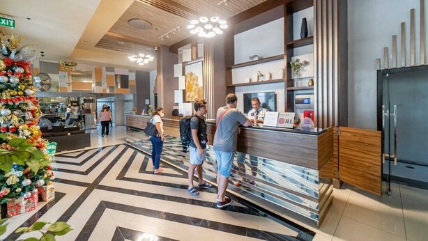 A modern lobby with a reception desk, a Christmas tree, and a check-in counter. - Infini by J&J ( City Center |Near Malls ) (Cebu City)