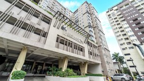 A multi-story building with a modern architectural design, featuring a prominent entrance with a canopy and a sign that reads "The Ipersimmon." - Infini by J&J ( City Center |Near Malls ) (Cebu City)