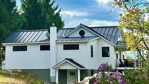 A two-story house with a gabled roof and a chimney. - Coastal Blue Heron Apartment at Tapley Farm, Blue Hill Peninsula, Acadia (Brooksville)