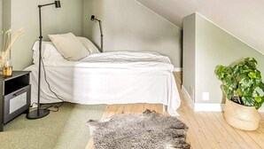A bedroom with a bed, bedside lamps, a small table, a plant, and a rug. - 3 Person Holiday Park Home in Bastad (Bastad)