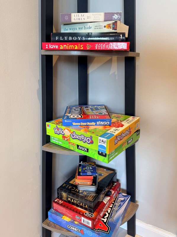 A bookshelf with a variety of books and board games.