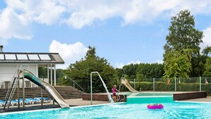 A swimming pool with two slides, a lifeguard tower, and lounge chairs. - 5 Person Holiday Park Home in Krusa (Krusaa)