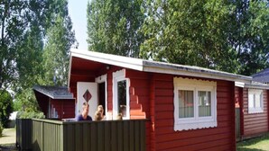 A red mobile home with a porch and a small deck. - 4 Person Holiday Park Home in Romo (Rømø)