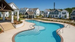 Zona residencial con piscina, casas y cielo despejado.