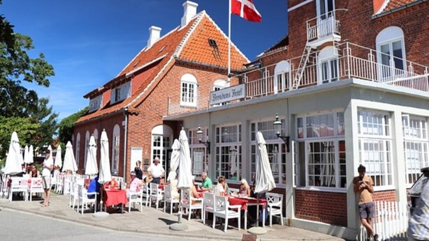 Un hôtel doté d’une terrasse et arborant un drapeau danois.