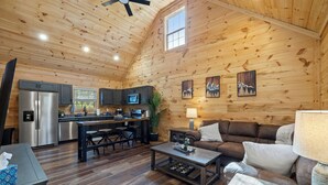 Un intérieur de chalet chaleureux comprenant une cuisine, un coin repas et un salon.