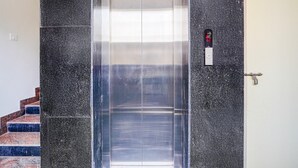 Un ascenseur doté d’un intérieur métallique, d’un panneau de commande et d’une poignée de porte.