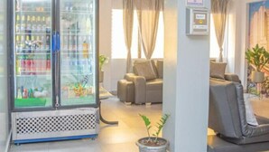 A hotel lobby with a seating area, a vending machine, and a potted plant. - Hotel Alcazar Medellin (Medellín)