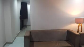 A modern living room with a sofa and a floor lamp.