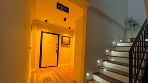 A staircase with a handrail, a door with a lock, and a sign indicating an exit. - Çiftlikte Konaklama Villa Saklı Bahçe (ordu)