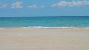 A beach with a clear sky and calm sea.