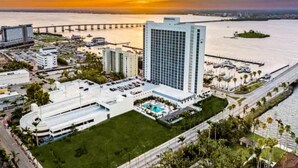 A high-rise hotel with a swimming pool and a view of the sunset over the water. - Luxury in the sky (Fort Myers)