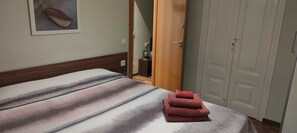 A hotel room with a bed, a door, and a wardrobe.