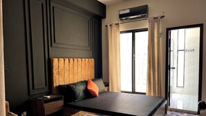 A modern bedroom with a large bed, a glass coffee table, a nightstand, and a sofa. - Entire 2 Bedroom Suite 5 (Islamabad)