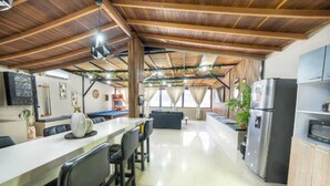 A spacious kitchen with a long counter, modern appliances, and a dining area with chairs.