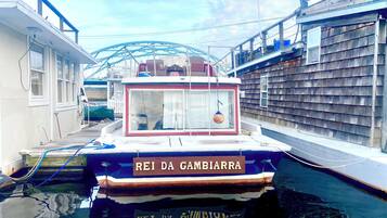 A narrow canal with a boat named "REI DA GAMBIARRA" docked at a pier.
