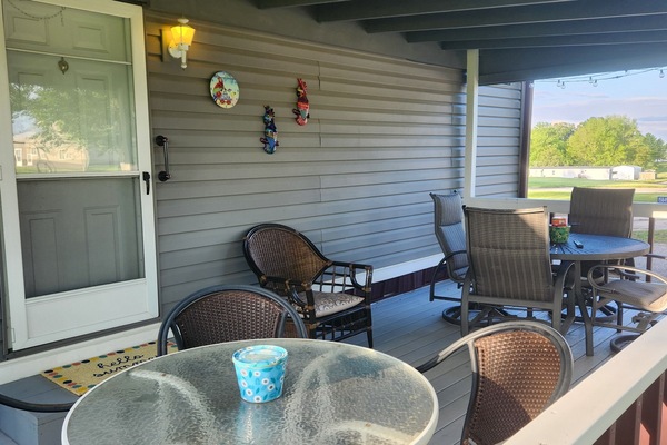 Covered deck faces the yard activities. Awesome deck furniture seats up to 9.