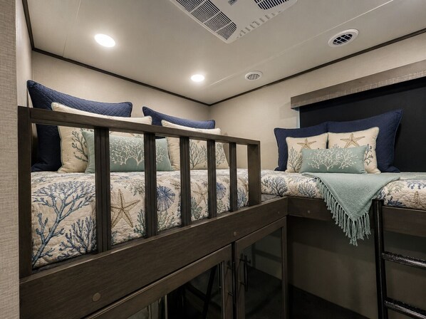 A bunk bed with a wooden frame and a headboard with a starfish design.