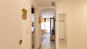 Un pasillo que conduce a un comedor con una mesa y sillas, un espejo y un cartel que dice 'hogar dulce hogar'.