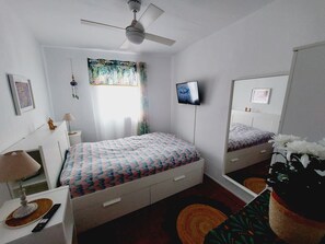A bedroom with a bed, bedside table, lamp, and a ceiling fan. - Andalusian House with Sea View in the Old Town (Almuñécar)