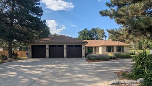 A two-story house with a garage, a driveway, and a well-maintained lawn.