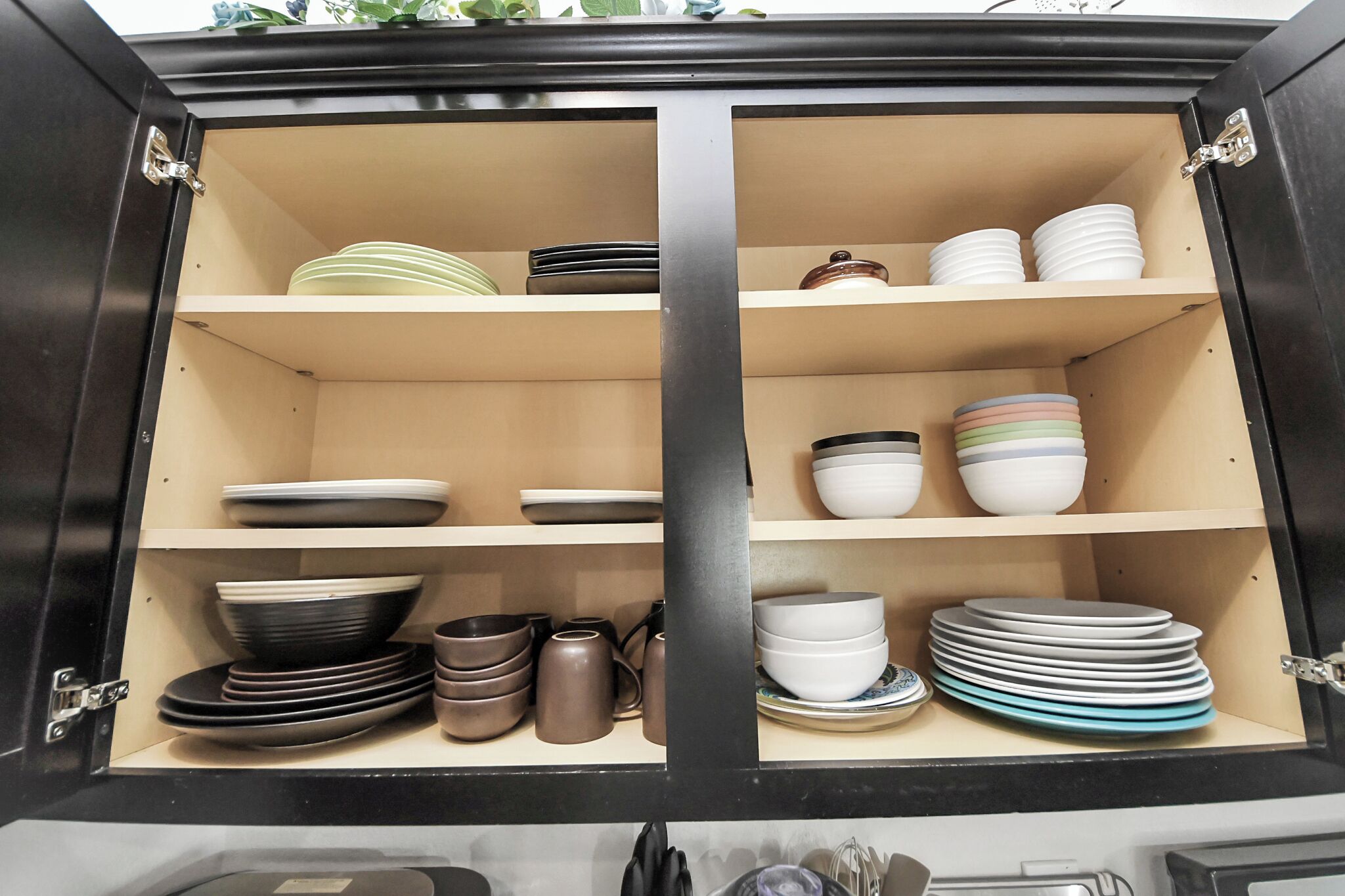 A cabinet with shelves containing various plates and bowls.