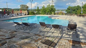 A swimming pool with lounge chairs and a stone-tiled deck. - Executive Edge, Lakeside (Bean Station)