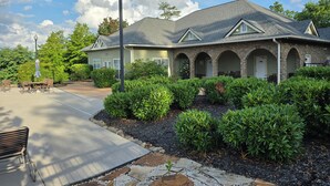 A two-story house with a stone facade, a covered patio, and a well-maintained garden. - Executive Edge, Lakeside (Bean Station)