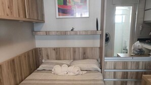 Una camera da letto con un letto, un comodino, una cassettiera e uno specchio.
