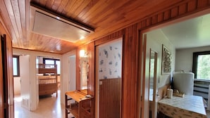 A wooden interior with a kitchen area, a dining table, and a bathroom with a shower. - T3 close to slopes for 6 people (Chantemerle)
