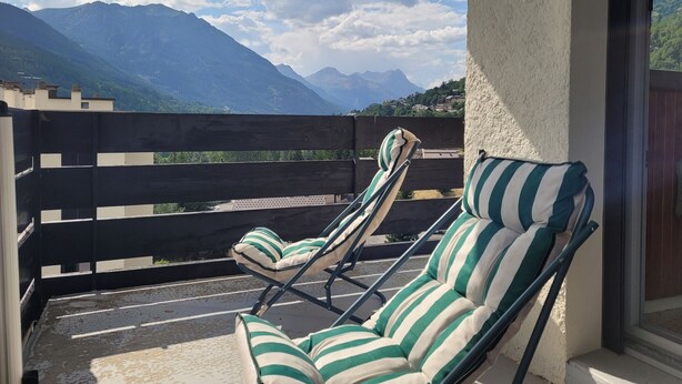 A balcony with two striped lounge chairs, a view of mountains, and a clear sky. - T3 close to slopes for 6 people (Chantemerle)