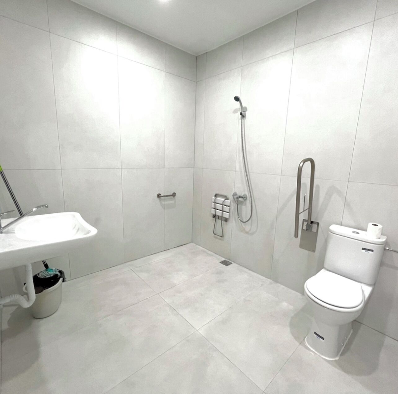 A modern bathroom with a sink, toilet, and shower.