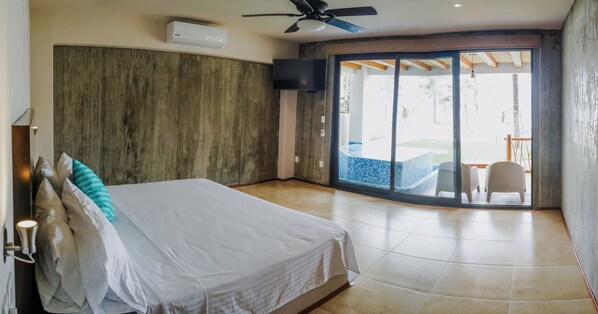 Un dormitorio con cama, ventilador de techo y vista a una piscina a través de un ventanal corredero.
