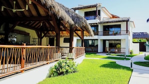 A resort with a thatched-roof structure, a pool area, and a well-maintained lawn. - Portofino Hotel & Restaurante (Barra de Potosi)